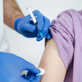A healthcare provider administering a vaccine to a patient's arm