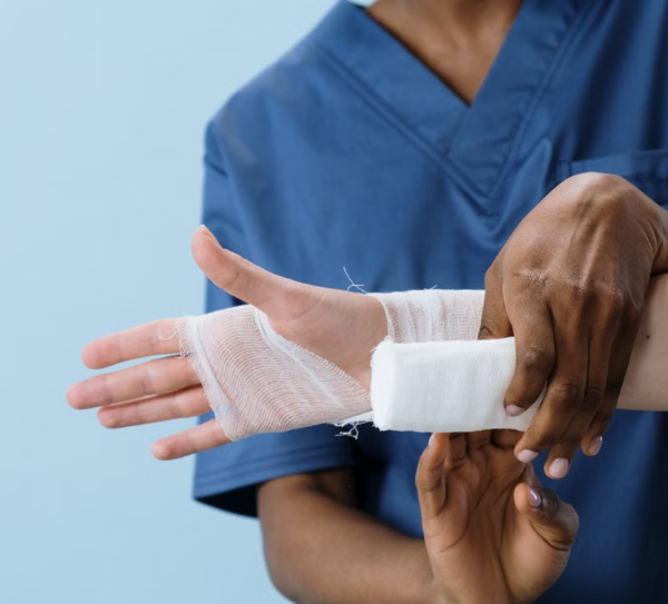 A healthcare provider gently bandaging a patient's hand after a minor procedure